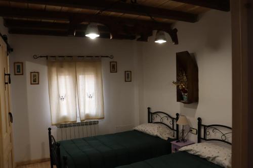 a bedroom with two beds and a window at Casa Rural Anita in Torre Baja