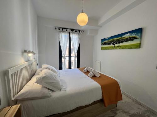 a bedroom with a bed with a large window at Ático San Bernardo Terraza y Parking Incluido in Seville