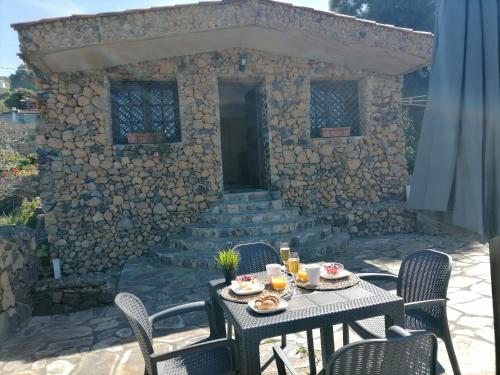 a table and chairs in front of a stone building at LA TAGORA Conect with the nature & relax in Icod de los Vinos