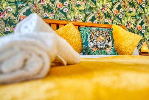 a tiger pillow on a bed with yellow pillows at Safari Stays - Gated - Sleeps 14 - Hot tub - Garden in Kidderminster