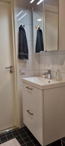 a white bathroom with a sink and a mirror at MM City Apartment Next to Arena in Tampere