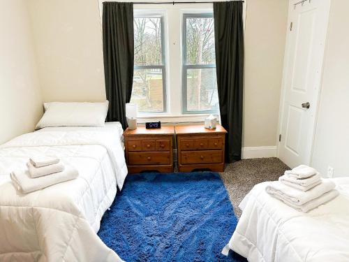 a bedroom with two beds and a blue rug at IvyLand Pines in Cleveland Heights