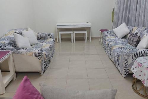 a living room with two couches and a table at stunning 2-bedroom flat in Ajman 