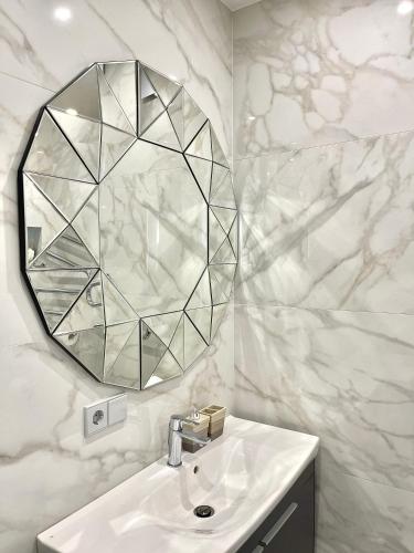 a bathroom with a sink and a mirror on the wall at Danes23 - Self Check-in, Free Parking, Park and River View, Oldtown in Klaipėda