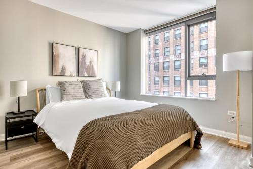 a bedroom with a large bed and two windows at Loop 1BR w gym pool lounge 1 block from L CHI-700 in Chicago