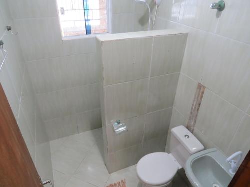 a white bathroom with a toilet and a sink at Casa na Rua da Praia com TV e Wi-fi in Pontal do Paraná