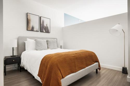 a white bedroom with a bed with a brown blanket at S Loop 1BR w Pool Gym Spa nr Grant Park CHI-741 in Chicago