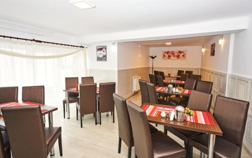 a dining room with tables and chairs in a restaurant at Pension Mora in Cluj-Napoca
