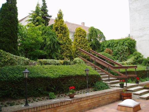 a stairway in a garden with a bench and flowers at Hotel Wollner in Sopron