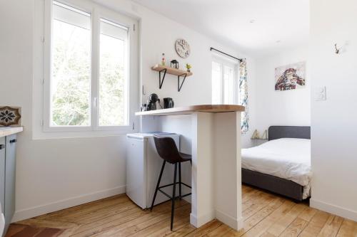 a bedroom with a bed and a desk in a room at Bel appart quartier Lardenne in Toulouse