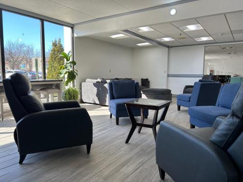 a waiting room with blue chairs and a table at Clarion Inn & Suites Grand Rapids Airport in Grand Rapids