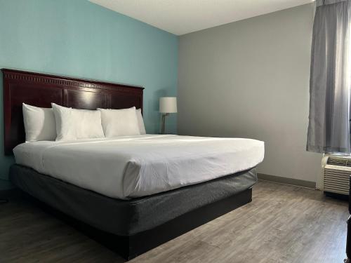 a bedroom with a large bed with a wooden headboard at Clarion Inn & Suites Grand Rapids Airport in Grand Rapids