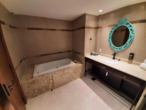 y baño con bañera, lavabo y espejo. en Hotel em Gramado - Buona Vitta en Gramado