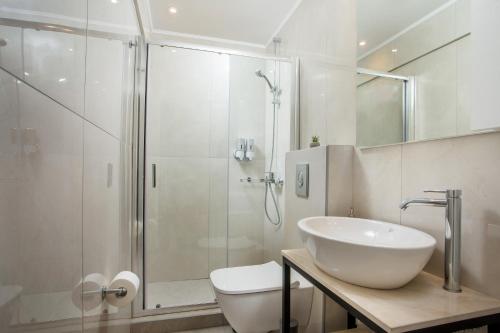 a bathroom with a shower and a sink and a toilet at Aetheria Central Apartments in Rhodes Town