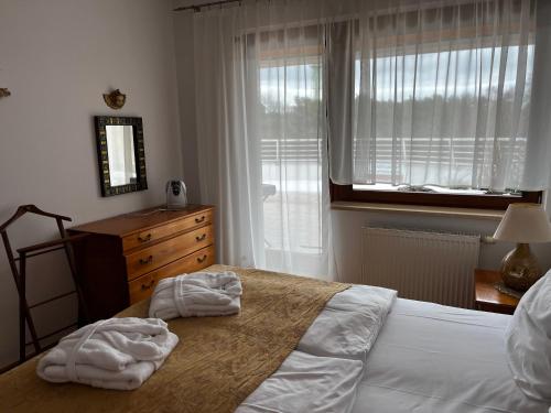 a bedroom with a bed and a dresser and a window at APARTAMENT 345 w Domu Zdrojowym - Jastarnia in Jastarnia