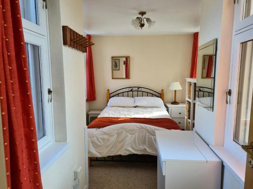una piccola camera da letto con un letto e una finestra di Skye Cottage, Meadowside House, near Kingussie a Kingussie