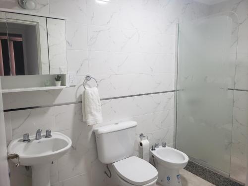 Baño blanco con aseo y lavamanos en Quilimbai Departamentos Turísticos en Malargüe