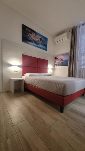 sypialnia z dużym łóżkiem z czerwonym zagłówkiem w obiekcie Affittacamere 5 Terre Dolci Sogni w mieście La Spezia