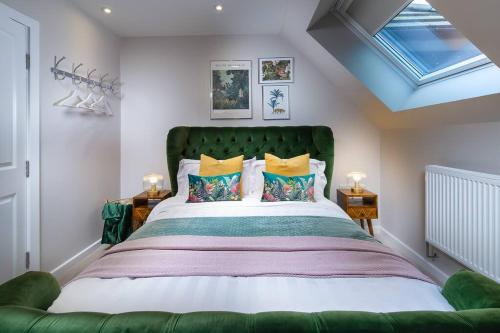 a bedroom with a large bed with a green headboard at Roseland Apartment 5 in Arundel