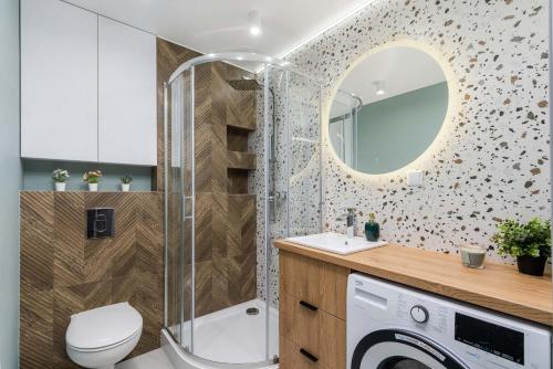 a bathroom with a shower and a toilet and a sink at Mint Apartments Tychy in Tychy