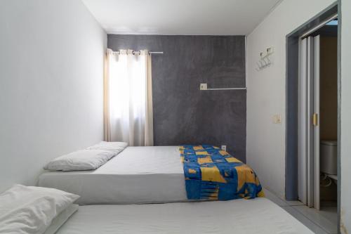 a bedroom with two beds and a window at Apt/Cas Porto de Galinhas in Porto De Galinhas