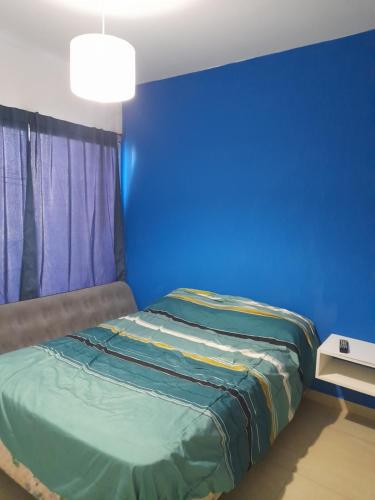Habitación azul con cama y pared azul en La casita de Loy en Tandil