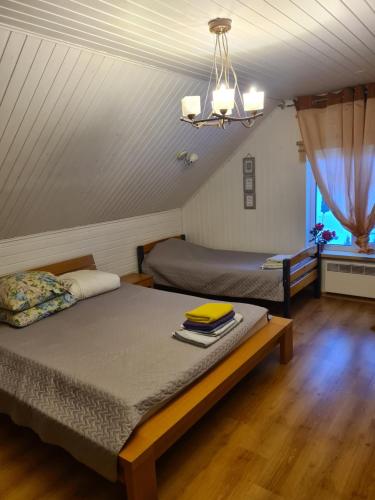 a bedroom with two beds and a chandelier at Rähni Guesthouse Lake Peipsi in Vilusi