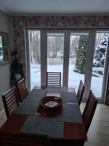 a dining room table and chairs with a snow covered yard at Rähni Guesthouse Lake Peipsi in Vilusi