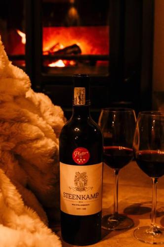 a bottle of red wine next to two wine glasses at Stone House McGregor in McGregor