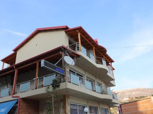 an apartment building with a sign on it at Fegi Rooms in Himare