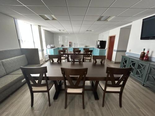 a dining room with a table and chairs and a couch at Clarion Inn & Suites Grand Rapids Airport in Grand Rapids