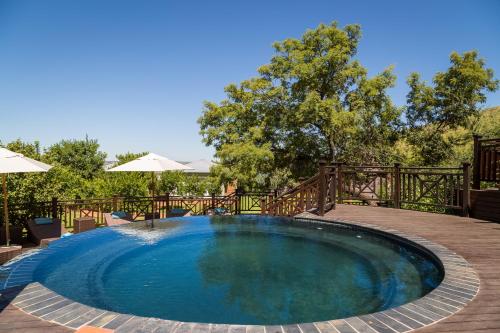 a swimming pool in a backyard with a wooden fence at Mount Grace Hotel & Spa in Magaliesburg