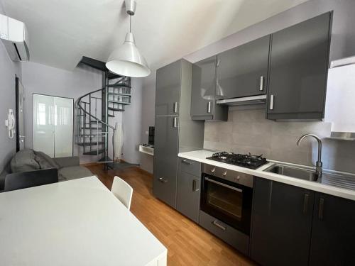 uma cozinha com armários pretos e um balcão branco em La Dolce Vita em Bovino