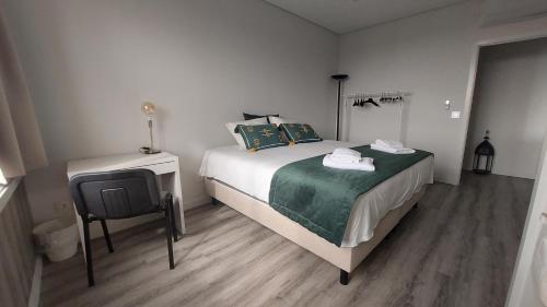 a bedroom with a bed and a table and a chair at Maia Apartment in Maia