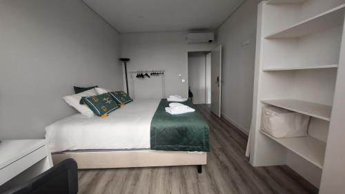 a small bedroom with a bed and shelves at Maia Apartment in Maia