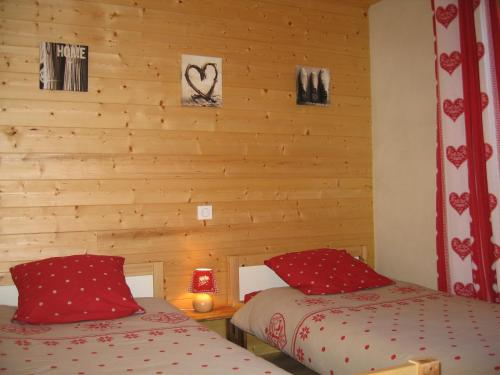 two beds in a room with wooden walls at Appartement Borne in Saint-Jean-d'Aulps