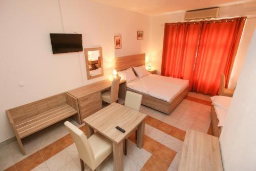 a living room with a bed and a table and a room with a bed at Lovely Home Rooms & Apartments in Mostar