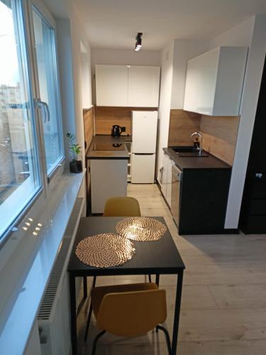 a small kitchen with a table and chairs in it at Apartament Stogi in Gdańsk