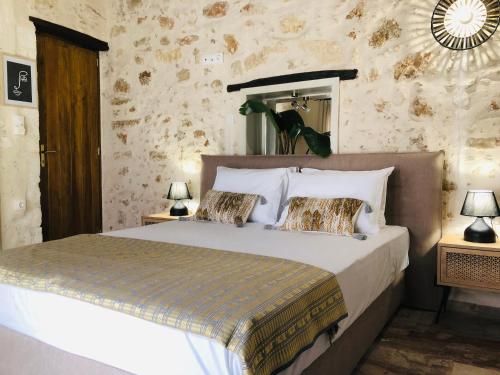 a bedroom with a large bed with two night stands at Gaia Luxury Rooms in Rethymno Town