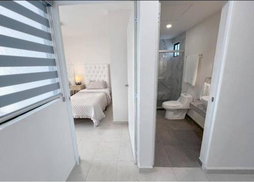 a white bathroom with a toilet and a bed at Departamento Exclusivo, High Apartment with Great Location 4-B in Matamoros