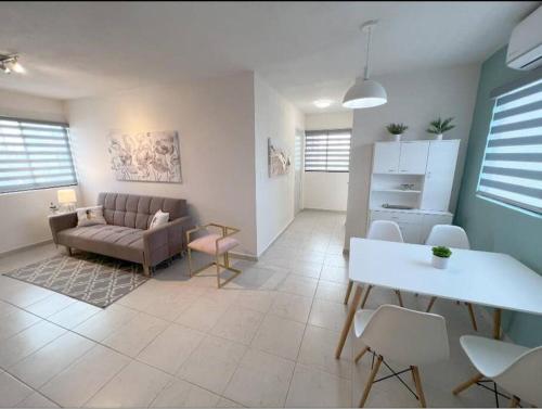 sala de estar con sofá, mesa y sillas en Departamento Exclusivo, High Apartment with Great Location 4-B en Matamoros