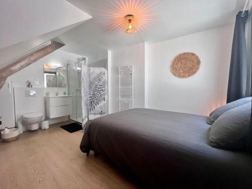 a bedroom with a bed and a bathroom at Casa Bondy - Sublime T2 Refait à Neuf - Hyper Centre de Brive in Brive-la-Gaillarde