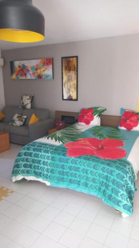 a bedroom with a large bed with a couch at L hibiscus in Saint-François