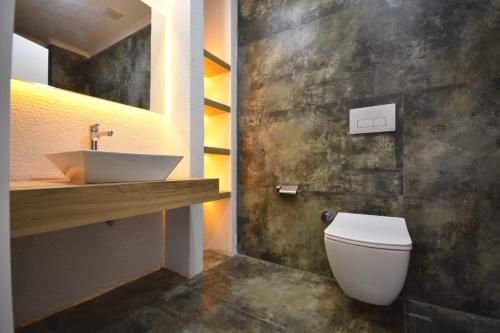 ein Badezimmer mit einem weißen WC und einem Waschbecken in der Unterkunft Mali Garden Residence in Side