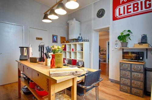 une cuisine avec une table et un panneau de pizza sur le mur dans l'établissement Sweet Nina Jazz Appartement pour 5 voyageurs, situé à la Place de la République, avec parking et lit queen size, au Mans