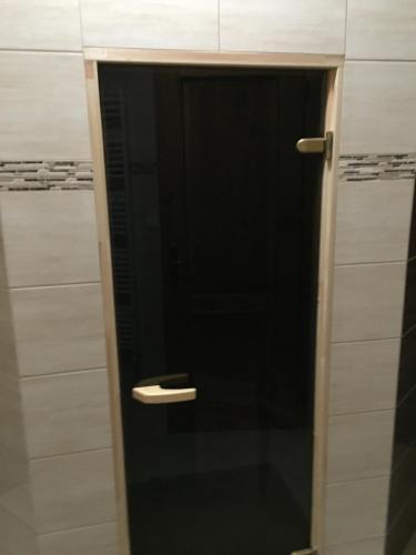 a black door with a handle in a bathroom at Chata Vločka - Orava Snow v lyžiarskom stredisku in Oravská Lesná