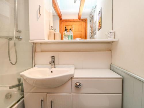 a small bathroom with a sink and a mirror at Corner Cottage in Staindrop