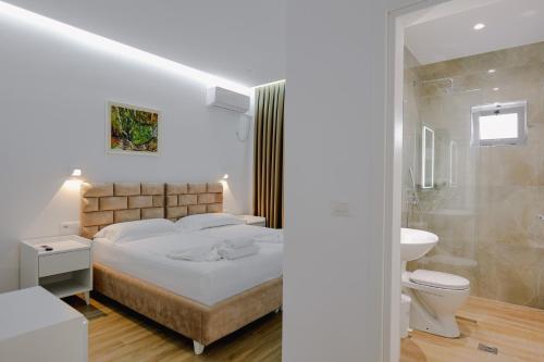 Schlafzimmer mit einem Bett, einem WC und einem Waschbecken in der Unterkunft Vila Jon'a in Sarandë