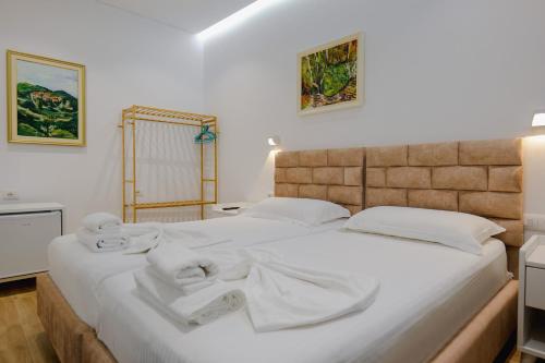 ein Schlafzimmer mit einem großen weißen Bett mit Handtüchern darauf in der Unterkunft Vila Jon'a in Sarandë