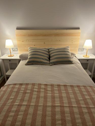 a large bed with two lamps on two tables at Casa La Rosada in Garray